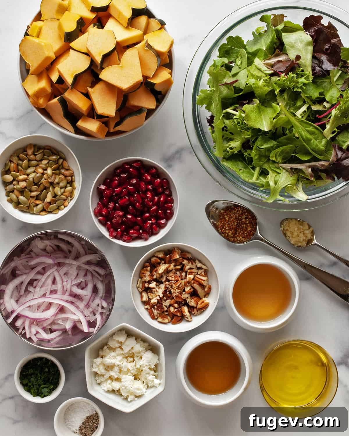 Golden Harvest Squash Salad 3 A flat lay photograph showcasing all the fresh ingredients needed for the roasted squash salad: vibrant squash, crisp lettuce, thinly sliced red onions, glistening pomegranate seeds, pumpkin seeds, pecans, creamy goat cheese, fresh parsley, and a bottle of olive oil.