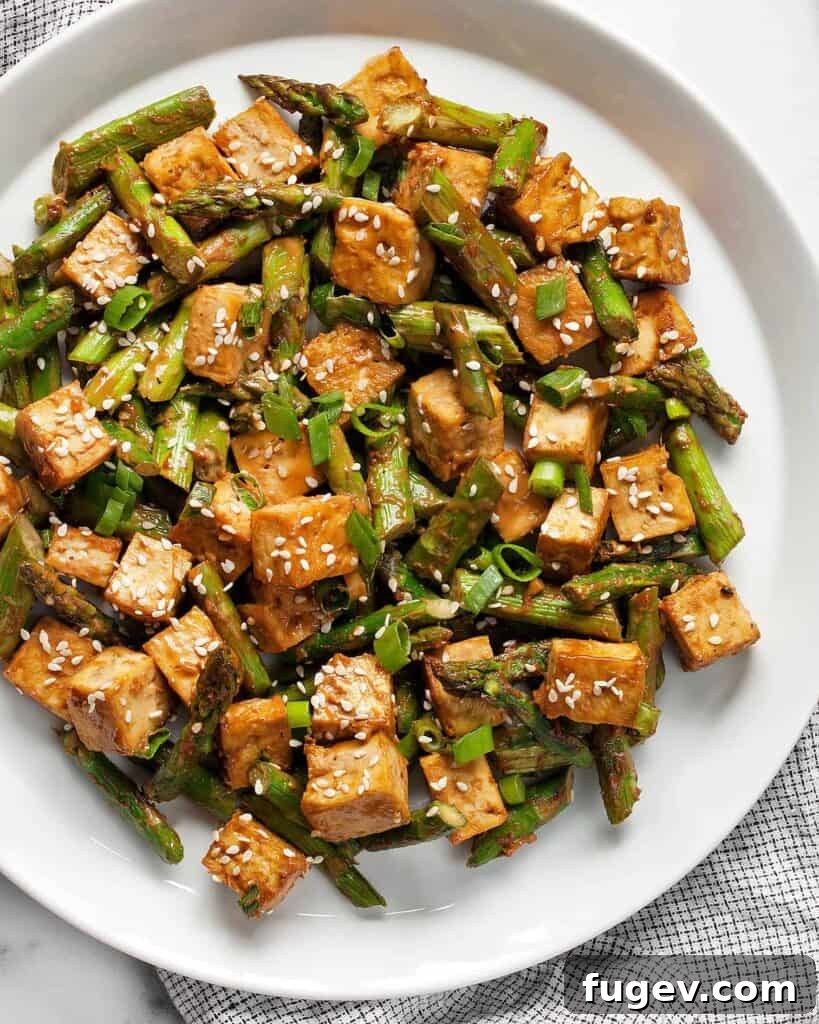Crispy Sesame Tofu and Roasted Asparagus Sheet Pan Dinner 2 Crispy Sesame Tofu and Asparagus baked on a sheet pan, ready to be tossed with sauce.