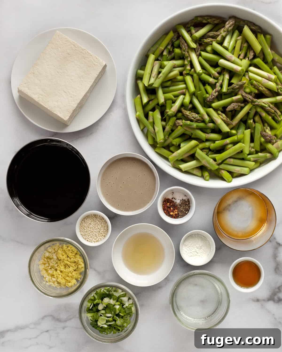 Crispy Sesame Tofu and Roasted Asparagus Sheet Pan Dinner 3 Collection of fresh ingredients for sesame tofu and asparagus including tofu, asparagus, soy sauce, tahini, maple syrup, rice vinegar, scallions, garlic, ginger, oil and seasonings.