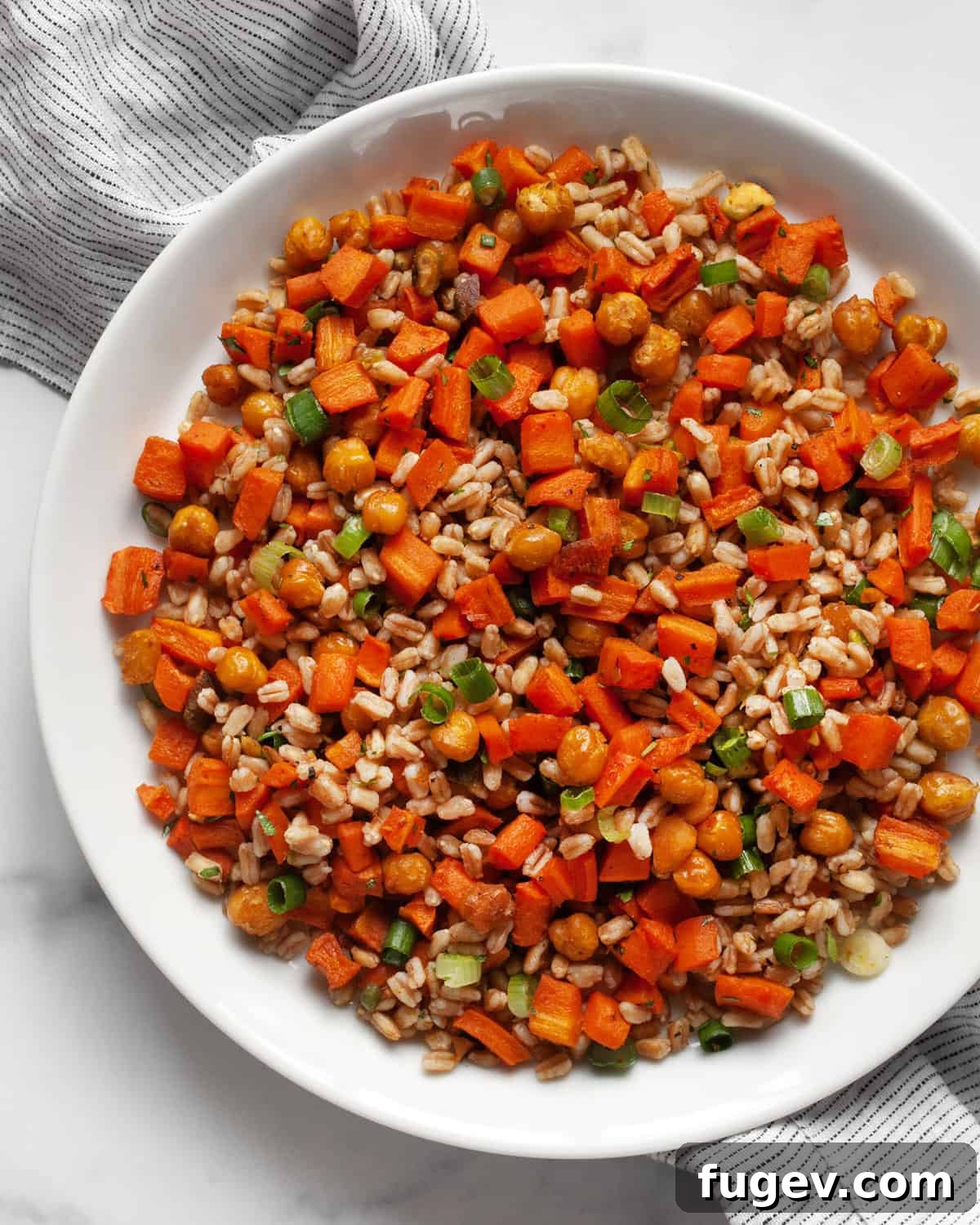 Caramelized Carrot Farro 7 A generous serving of roasted carrot and chickpea farro on a white plate, ready to be enjoyed.