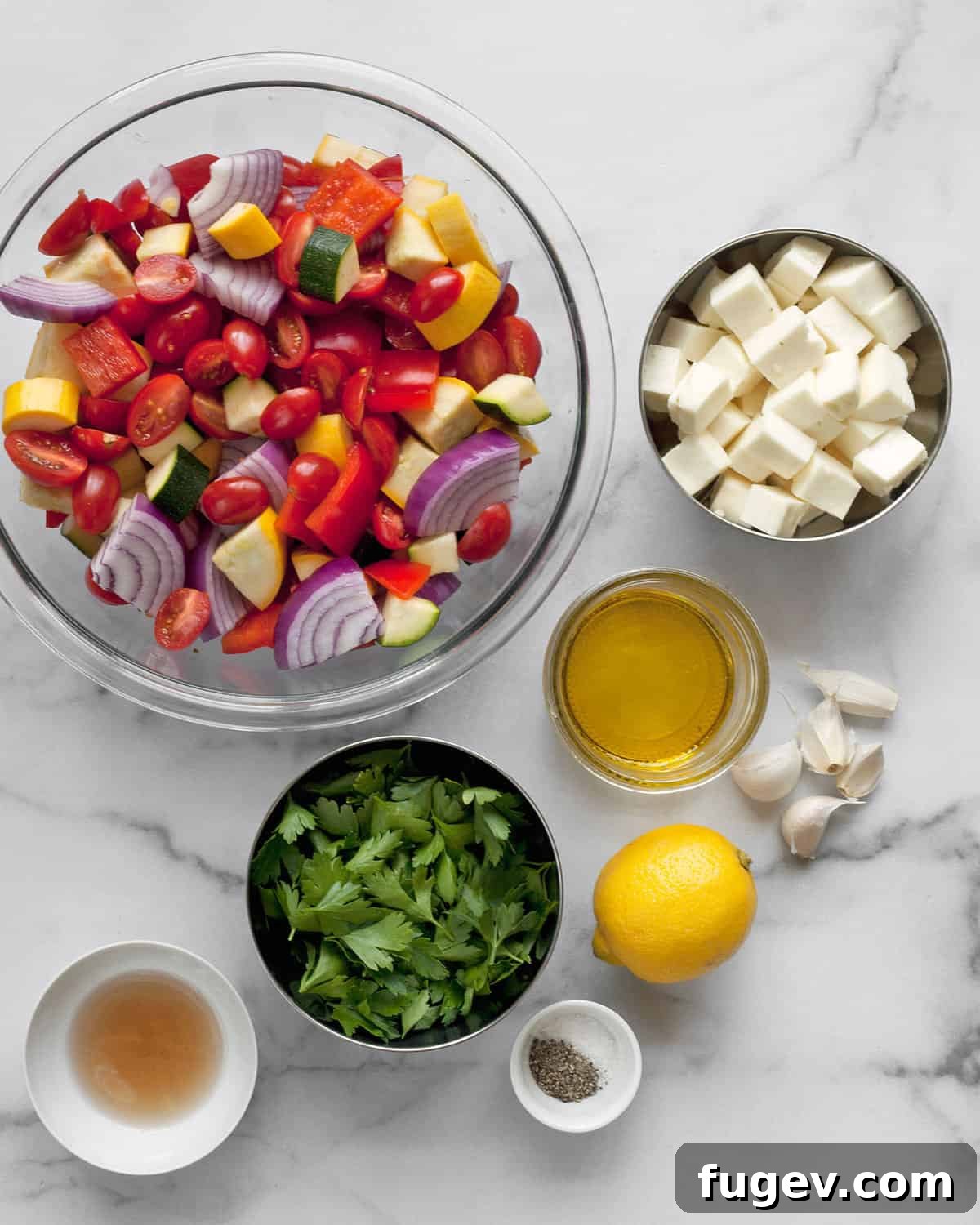 Golden Halloumi & Vibrant Mediterranean Roast 3 Fresh ingredients including colorful vegetables, halloumi cheese, fresh parsley, garlic cloves, lemon, vinegar, and olive oil, laid out for Mediterranean roasting.