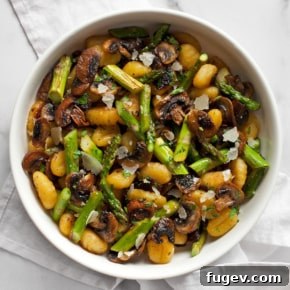 Roasted asparagus mushroom gnocchi in a bowl with fresh herbs