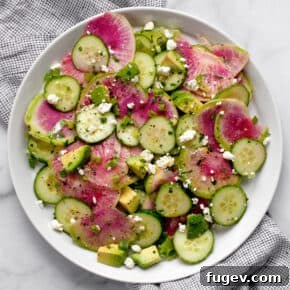 Visually stunning watermelon radish, cucumber, and avocado salad on a light plate
