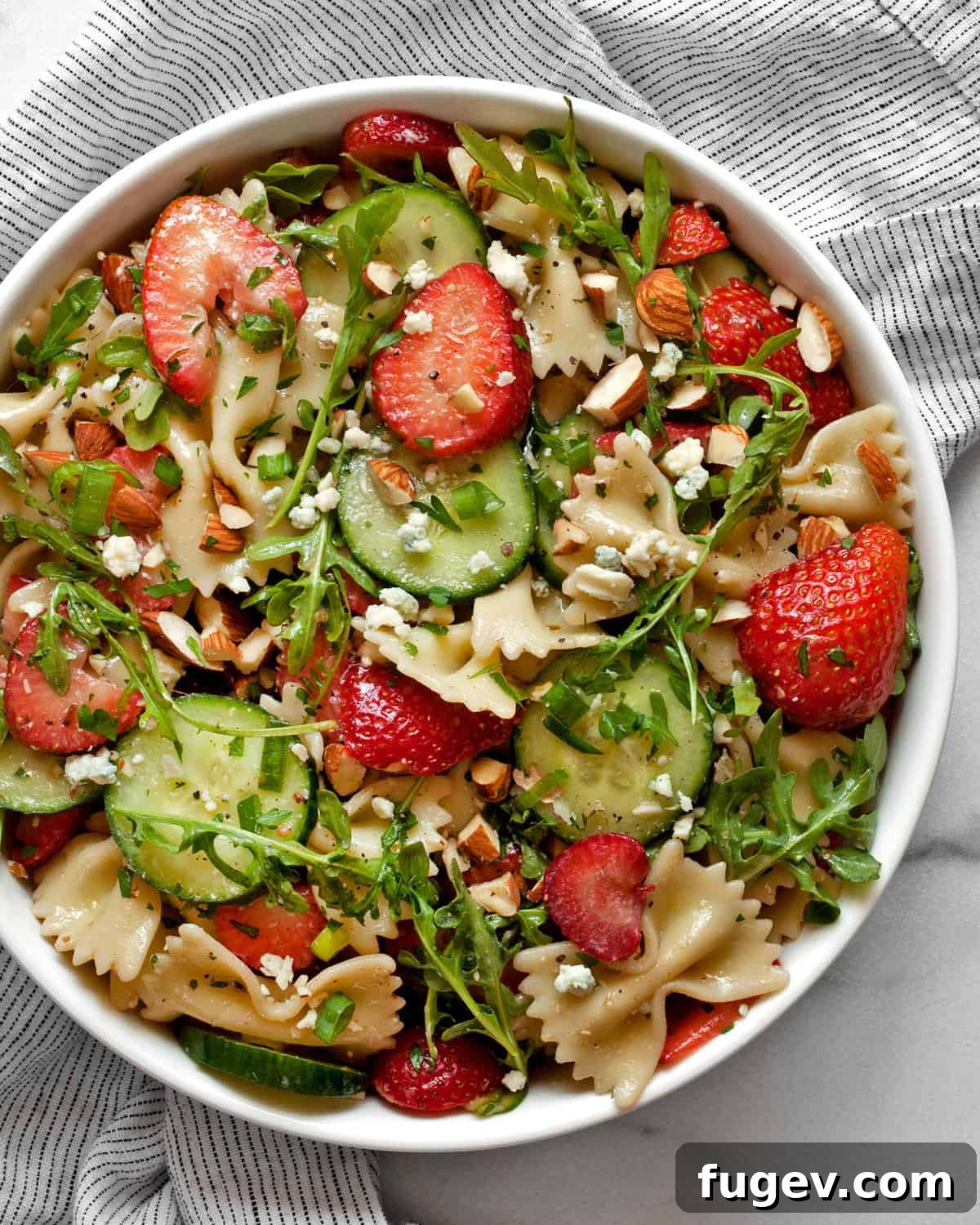 Strawberry Cucumber Pasta Medley 2 Cucumber pasta salad with strawberries and almonds in a bowl.