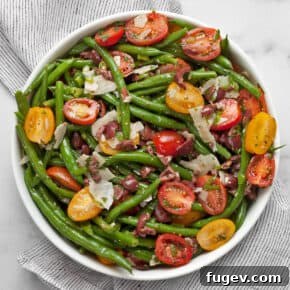 Green bean tomato olive salad in a bowl.