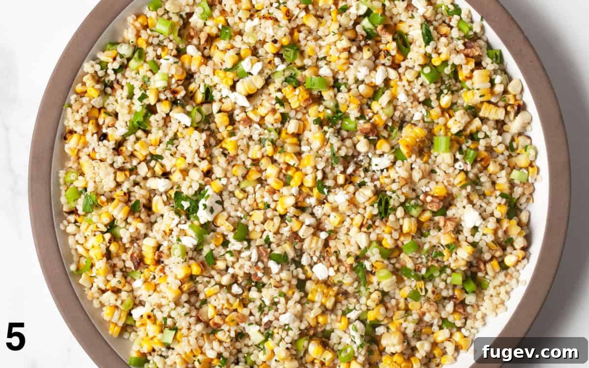Smoky Corn Couscous Salad 6 A close-up image of the grilled corn couscous after all ingredients have been combined and stirred in a large bowl, ready to be served.