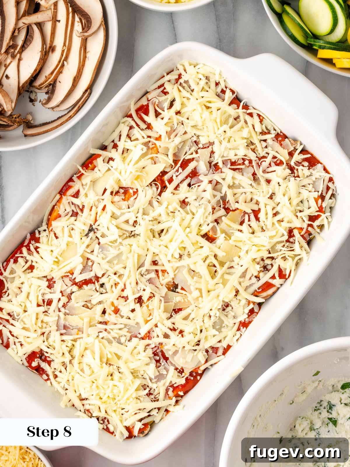 Vibrant Veggie Lasagna 12 A glorious topping of shredded mozzarella and Parmesan cheese covering the top layer of the vegetable lasagna, ready for baking.