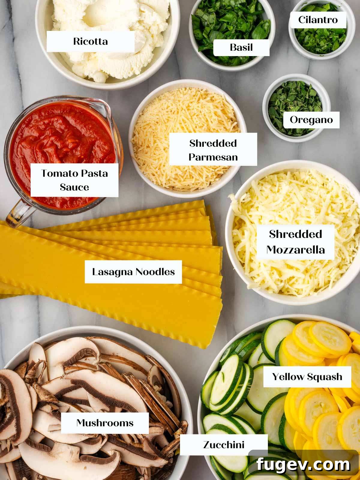 Vibrant Veggie Lasagna 4 Fresh ingredients for vegetable lasagna laid out on white marble countertop, including zucchini, squash, mushrooms, cheeses, herbs, and lasagna noodles.