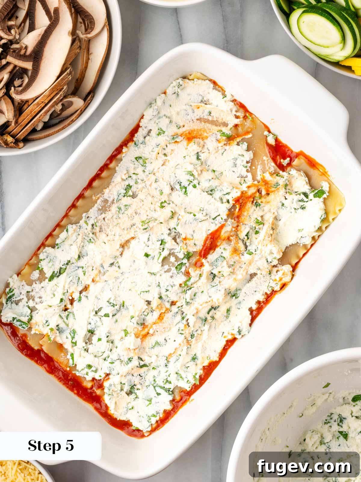 Vibrant Veggie Lasagna 7 Spreading a layer of seasoned ricotta cheese mixture evenly over lasagna noodles in a baking dish.
