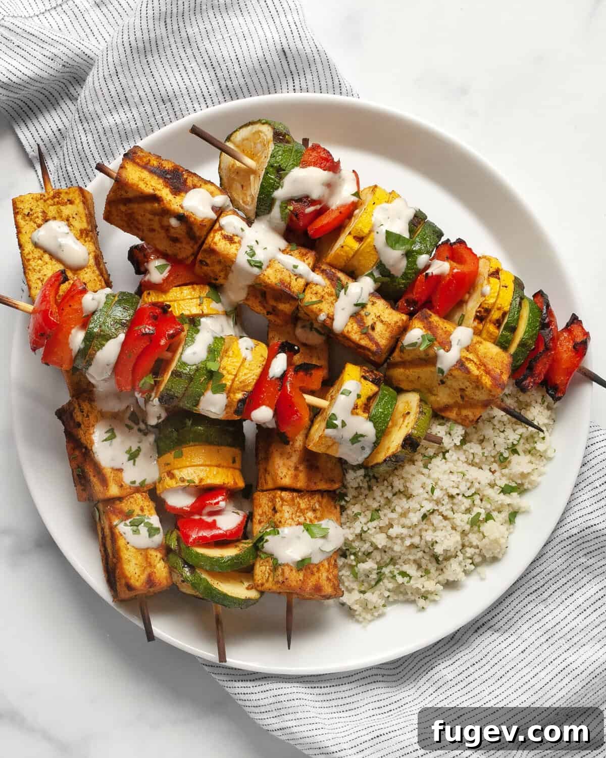 Spiced Grilled Tofu Shawarma 2 Grilled tofu and vegetable skewers with couscous on a plate, ready to be served.