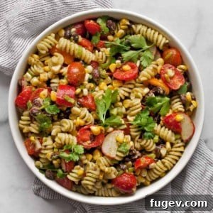 Fiesta Pasta Salad 7 A top-down view of a serving of Southwest pasta salad in a white bowl, garnished with fresh cilantro.
