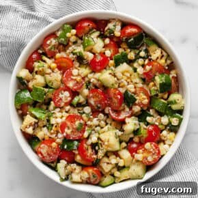 Grilled zucchini salad with corn and tomatoes in a bowl.