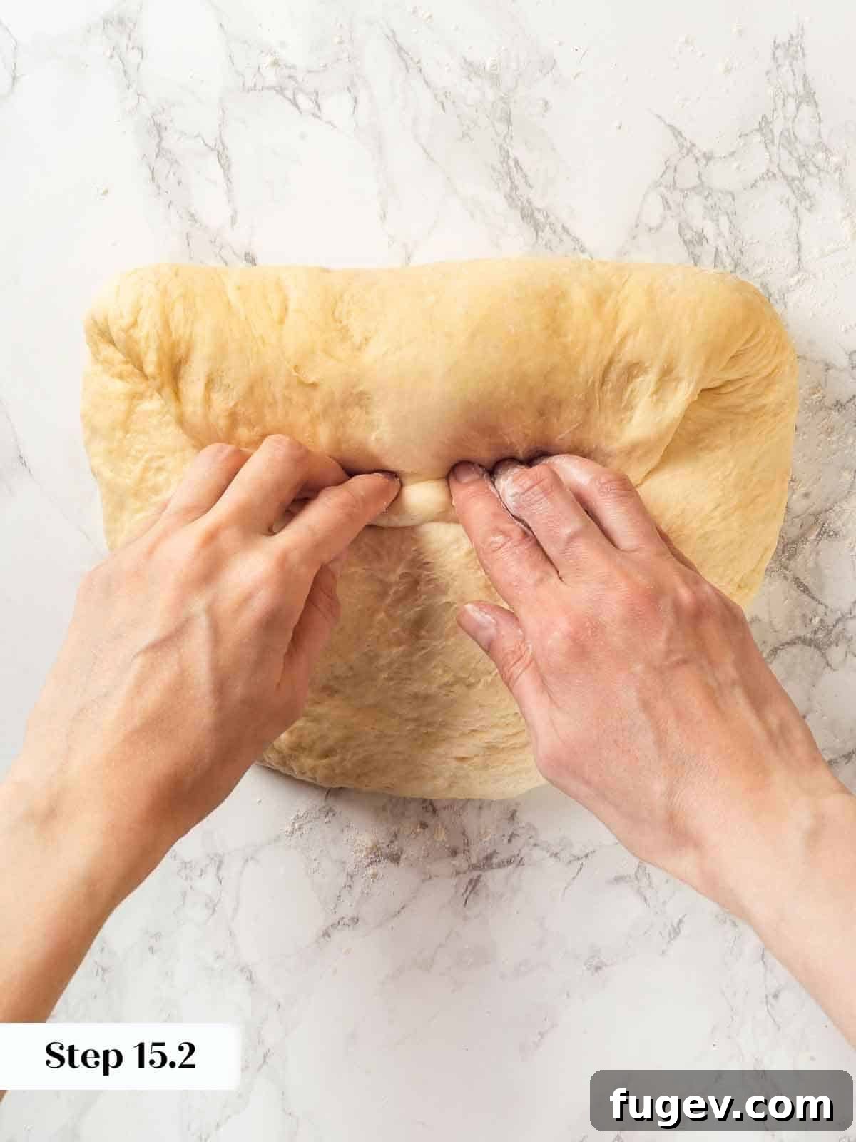 Pillowy Potato Loaf 16 A baker carefully folding potato bread dough into a compact shape for shaping.