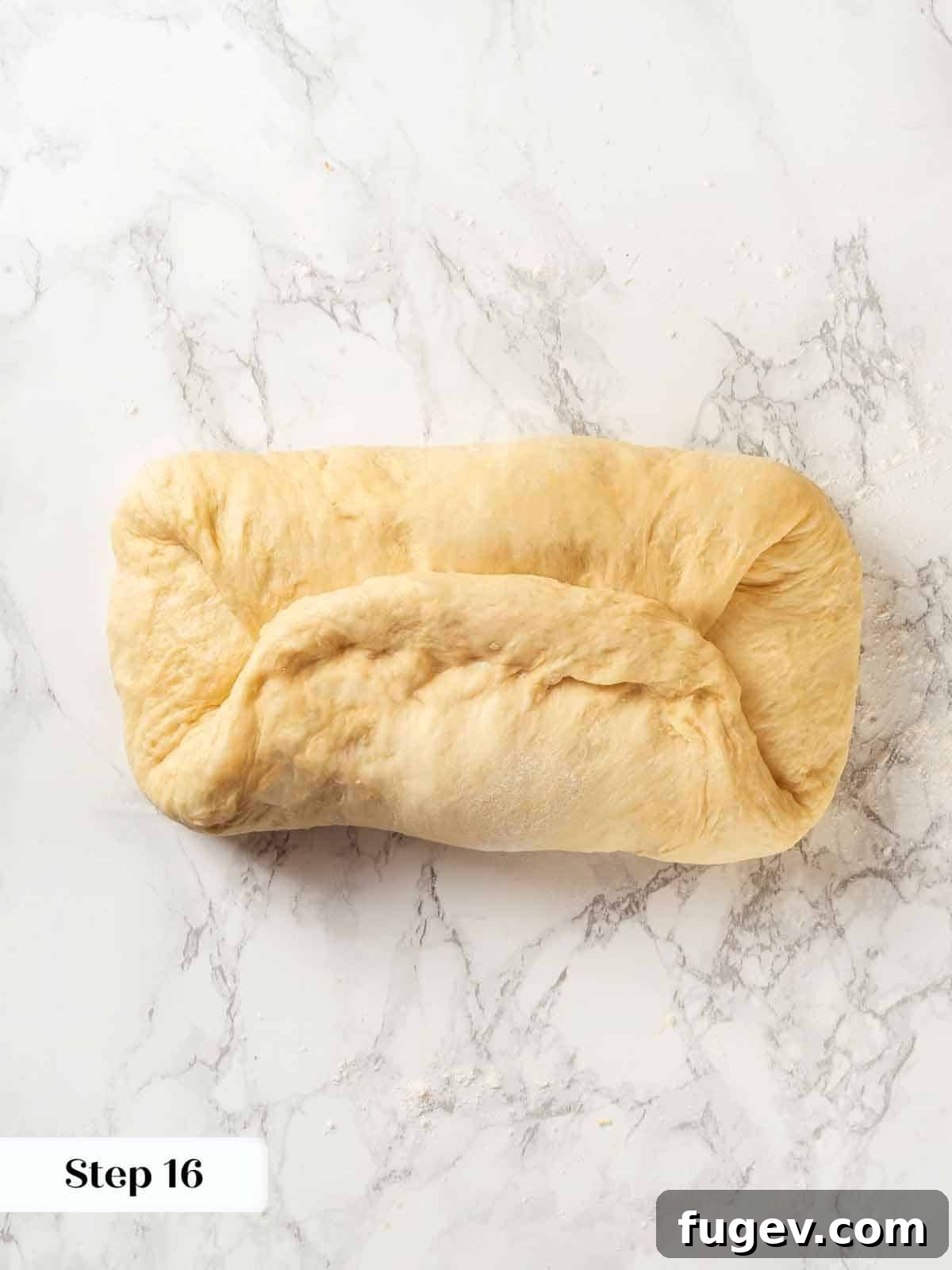 Pillowy Potato Loaf 18 A baker demonstrating repeated folds in potato bread dough for strength.