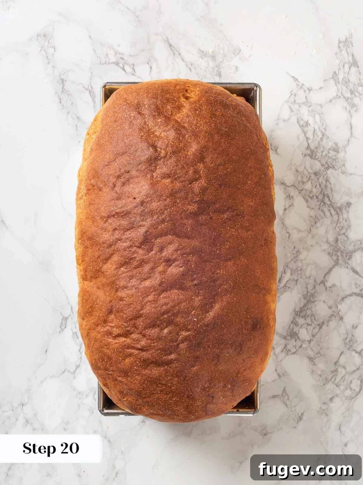 Pillowy Potato Loaf 21 A fully baked loaf of potato bread in a metal loaf pan, golden and fluffy.