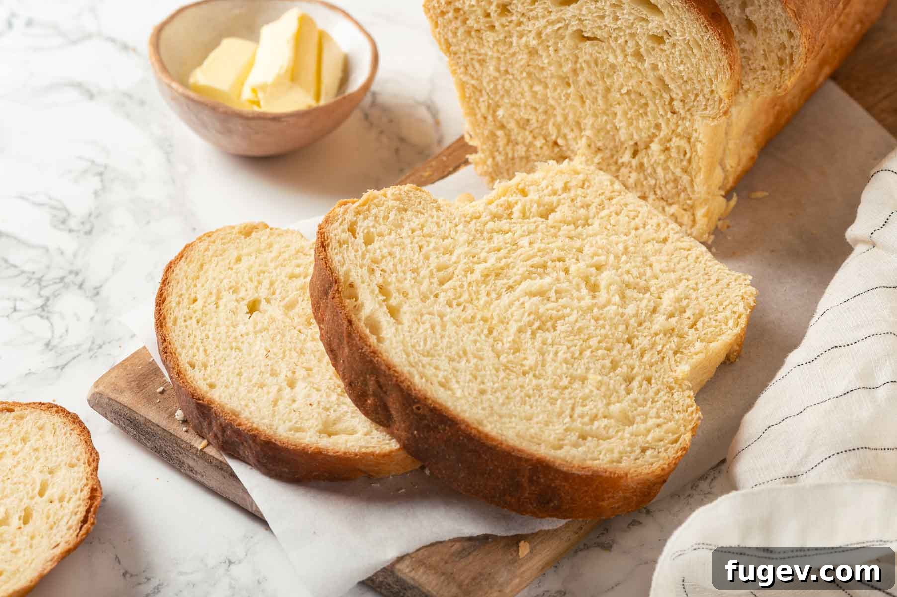 Pillowy Potato Loaf 5 Freshly baked potato bread with a butter dish beside it, perfect for serving.