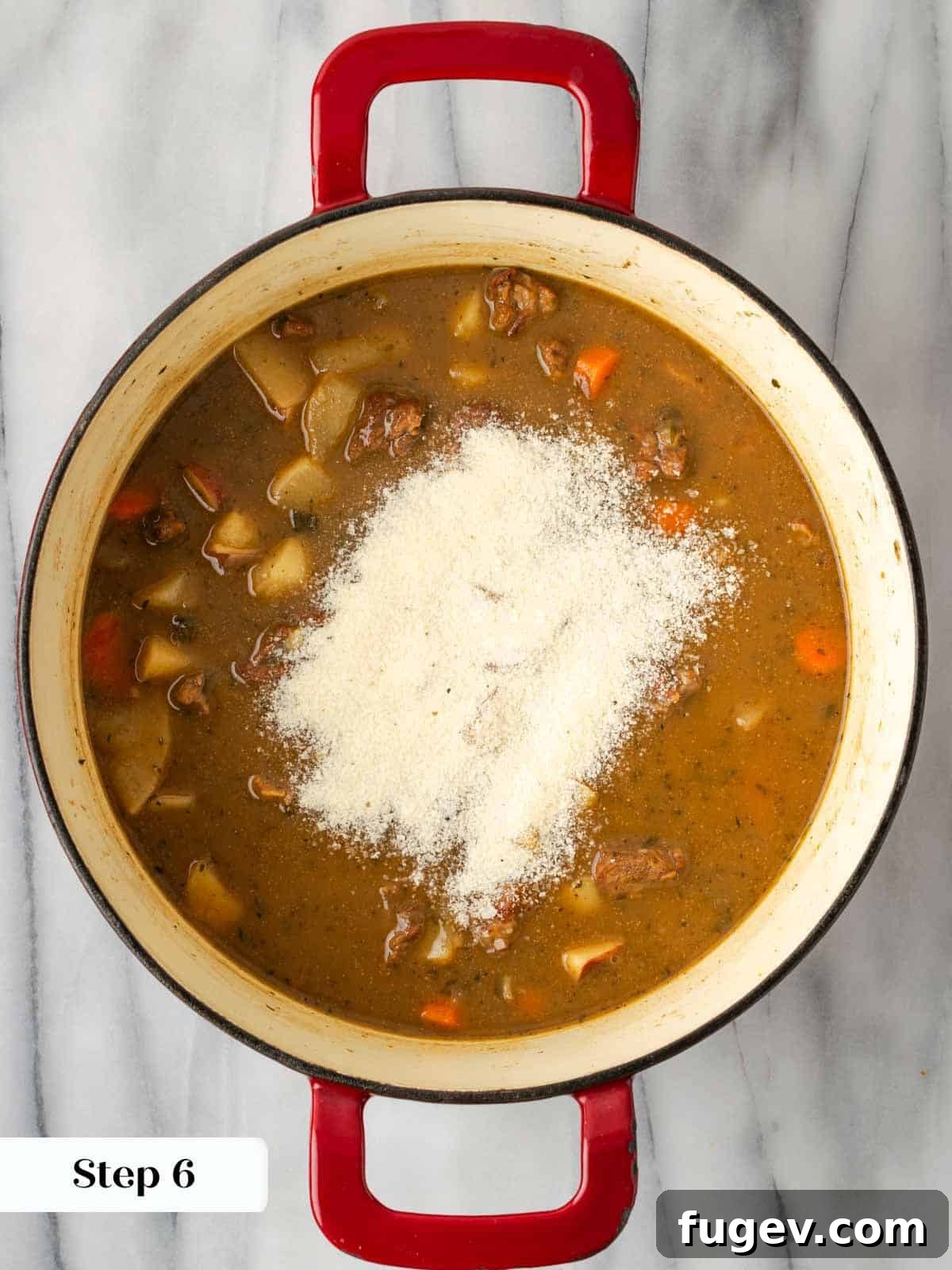 Classic Cast Iron Beef Stew 11 Thickening beef stew with a piece of soda bread, which is dissolving into the broth.