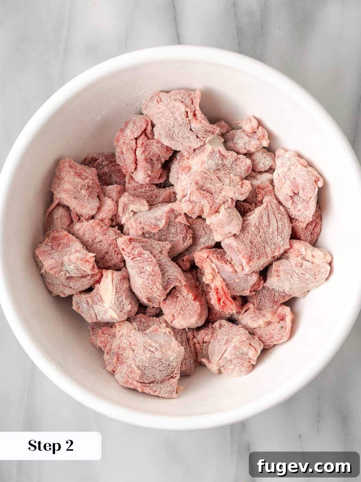 Classic Cast Iron Beef Stew 7 Flour-coated beef stew meat in a bowl, ready for browning.