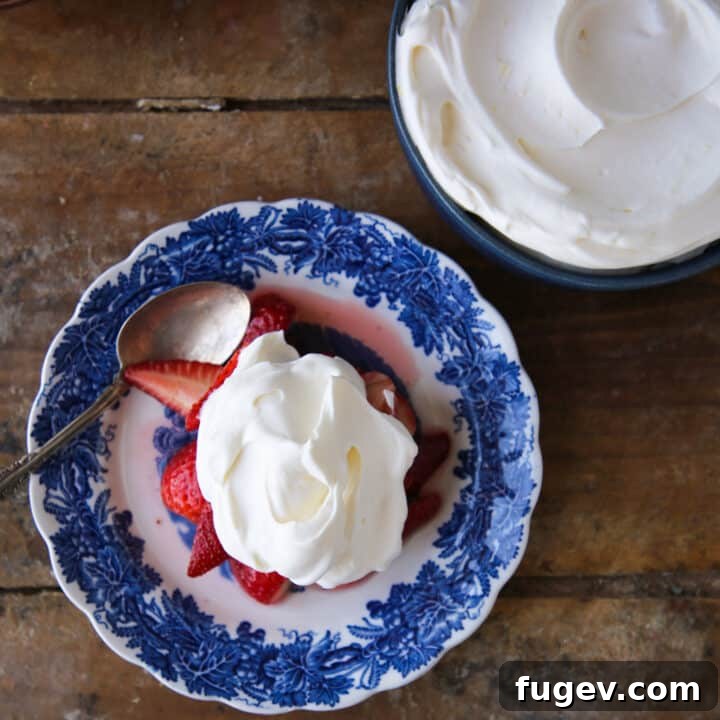 Zesty Cloud Cream 3 Lemon Whipped Cream served on a blue plate alongside fresh strawberries