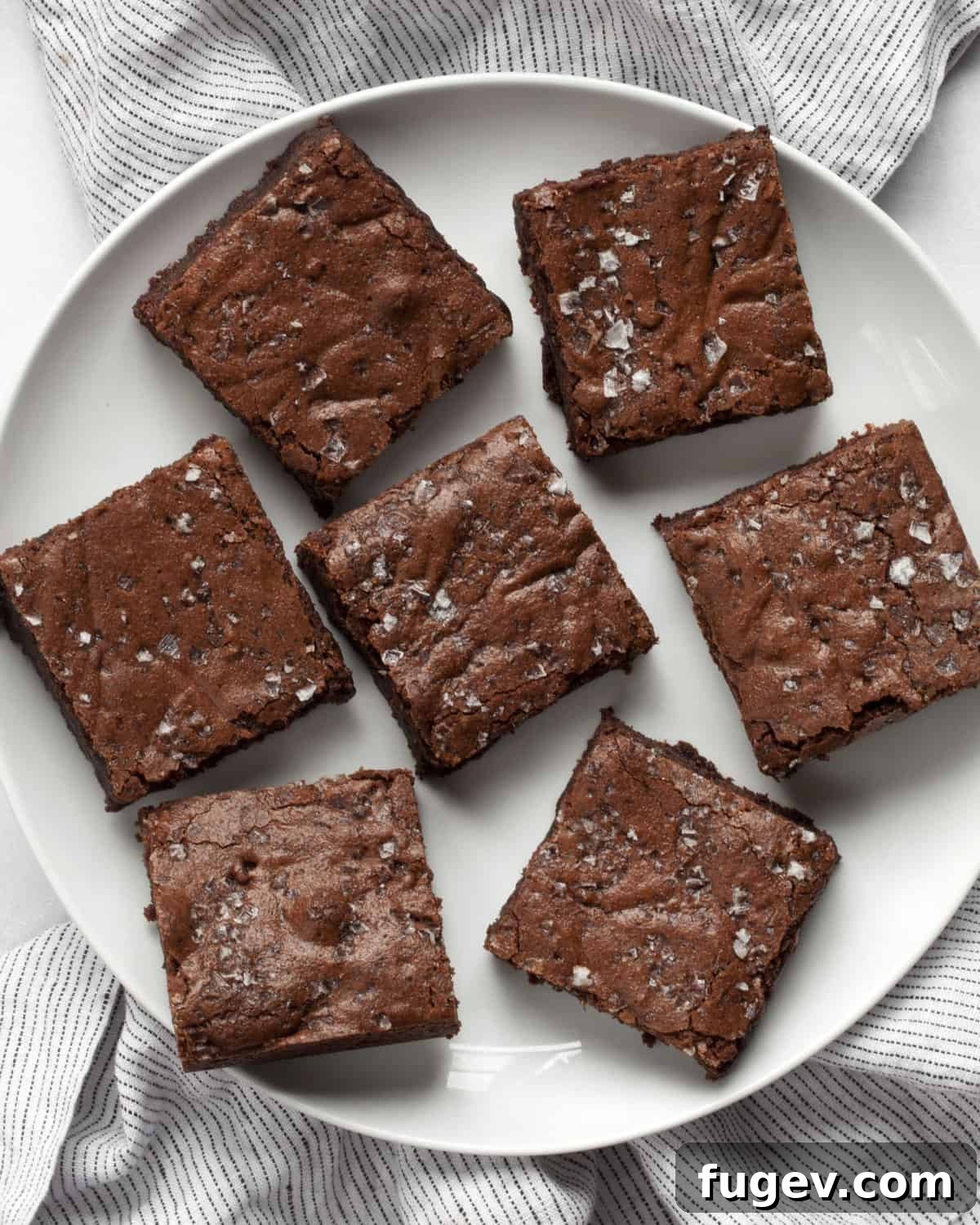Effortless Salted Fudge Brownies 7 A plate with two fudgy brownies, showing their rich texture and sea salt topping.