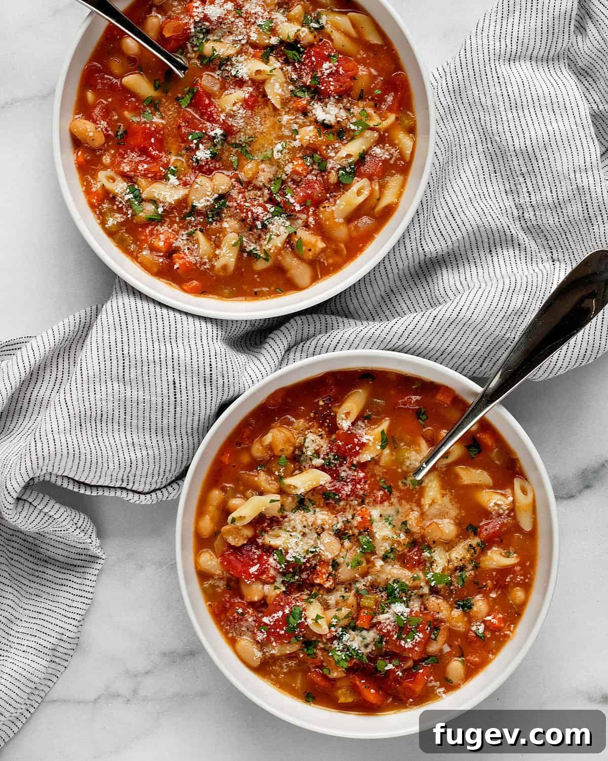 Hearty Italian Pasta Fagioli Soup 2 Two steaming bowls of hearty Pasta e Fagioli soup, garnished with fresh parsley and Parmesan cheese, invitingly presented.