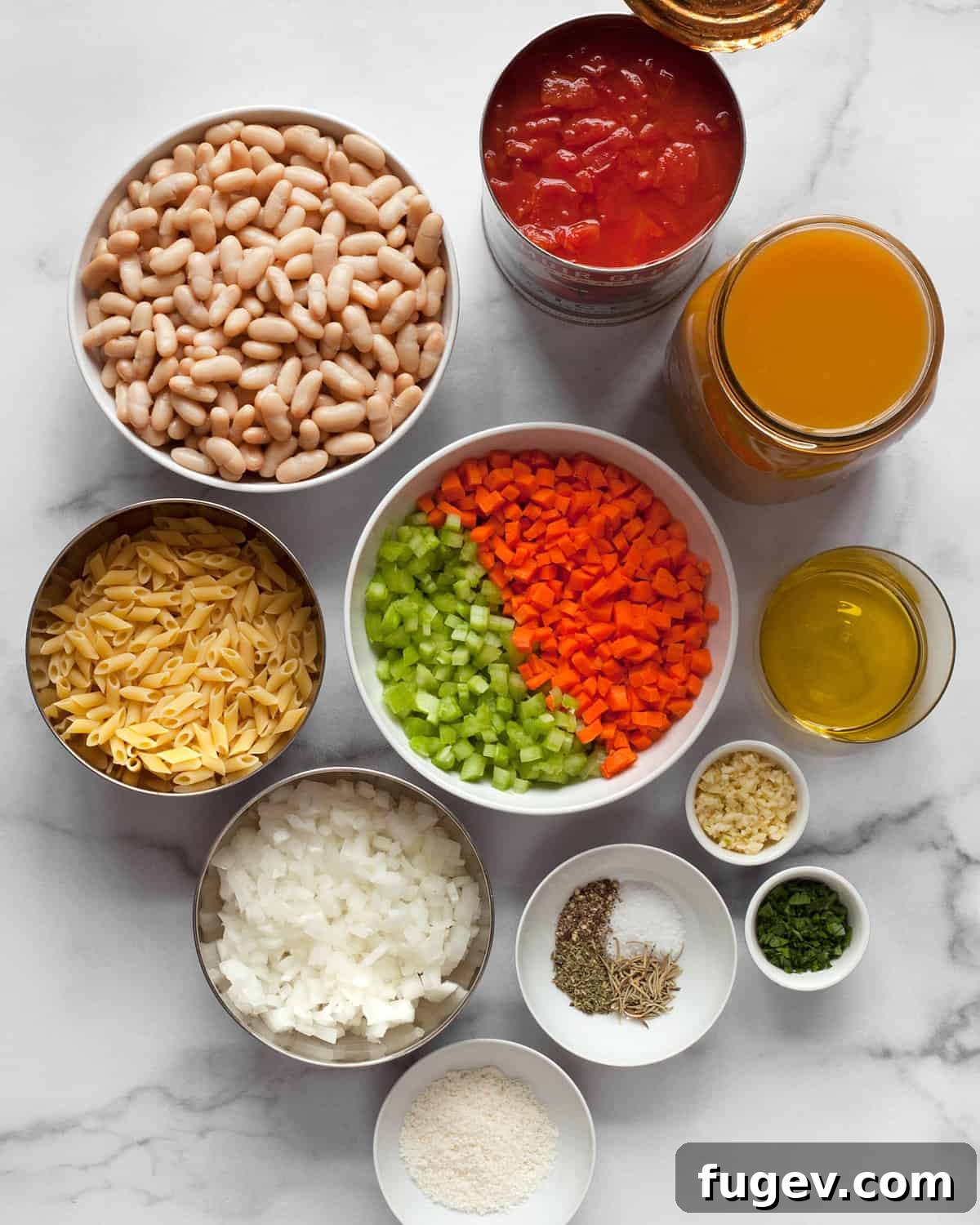Hearty Italian Pasta Fagioli Soup 3 A vibrant selection of fresh ingredients including onions, carrots, celery, canned beans, diced tomatoes, vegetable broth, fresh garlic, and dried spices laid out on a kitchen surface, ready for cooking.