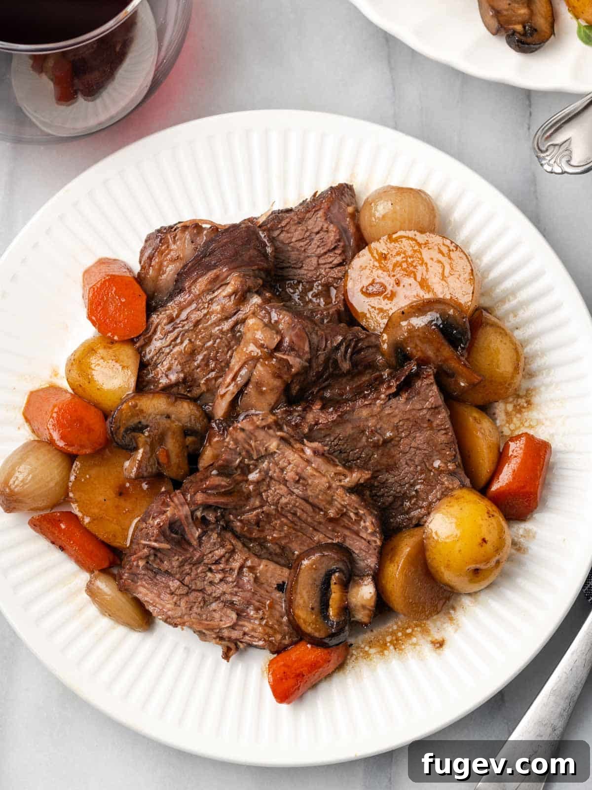 Finished Pot Roast Presentation Close-up of sliced pot roast with perfectly cooked vegetables on a platter.