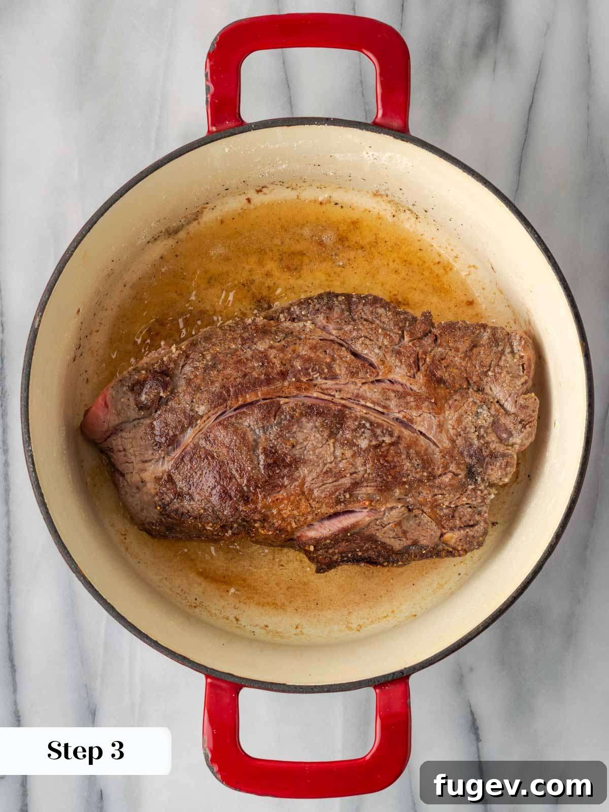 Searing Beef in Dutch Oven Searing a seasoned pot roast in a hot Dutch oven with butter and olive oil.