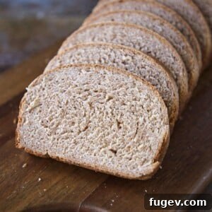 Whole wheat bread sliced on a wooden board, ready to be enjoyed.