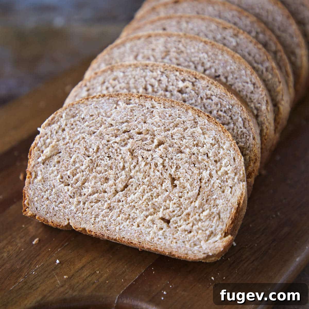 Whole Wheat Sourdough Bread 4 Beautifully sliced whole wheat bread on a cutting board, highlighting its texture.