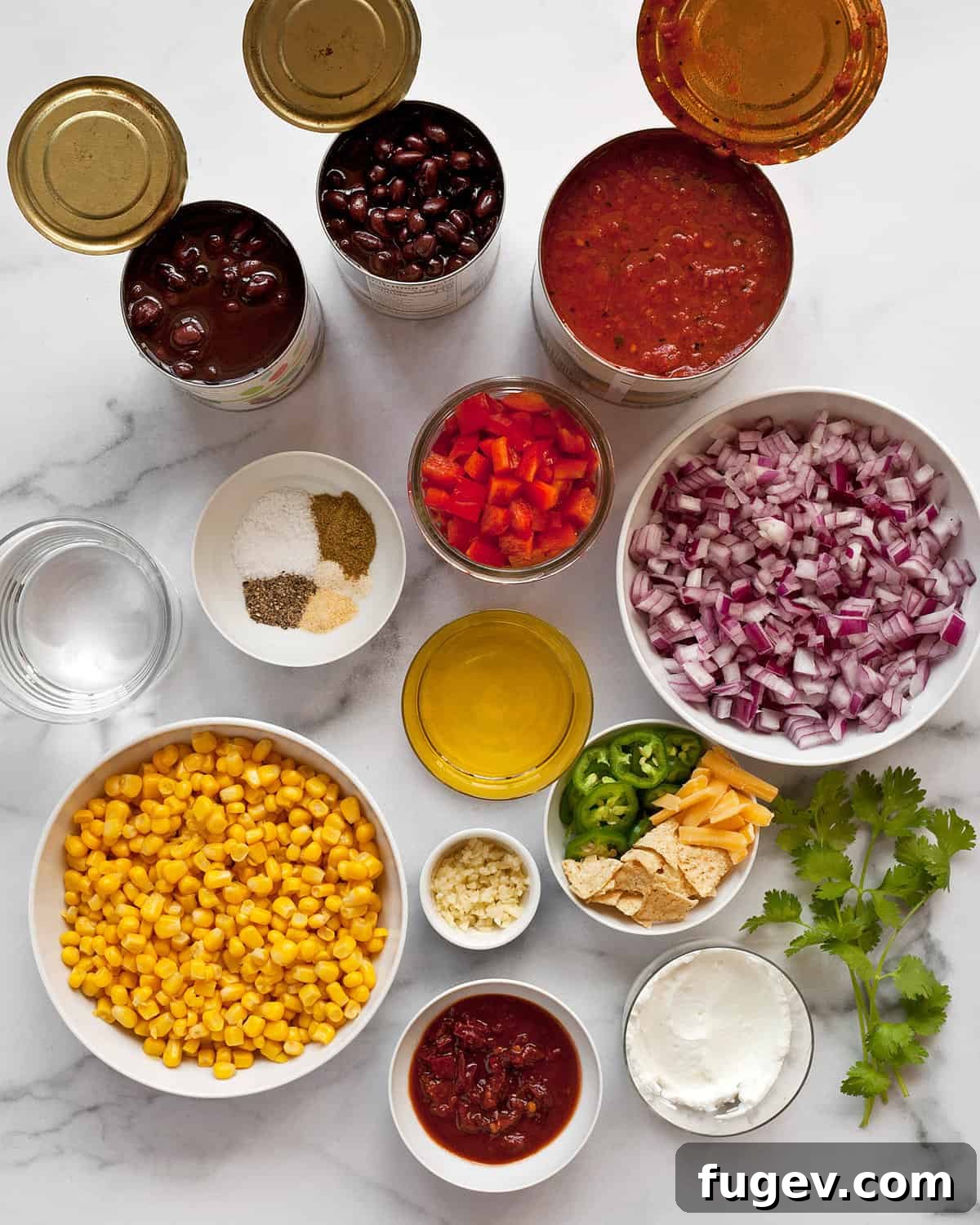 Savory Black Bean Sensation 3 A vibrant selection of ingredients laid out, including black beans, fire-roasted tomatoes, corn, red onions, red peppers, various spices, olive oil, and chipotles en adobo.