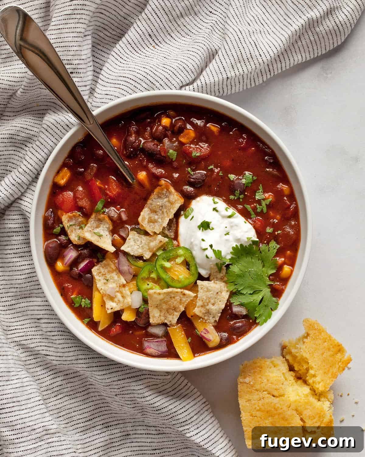 Savory Black Bean Sensation 7 A comforting bowl of black bean chili, accompanied by a piece of golden, torn cornbread.