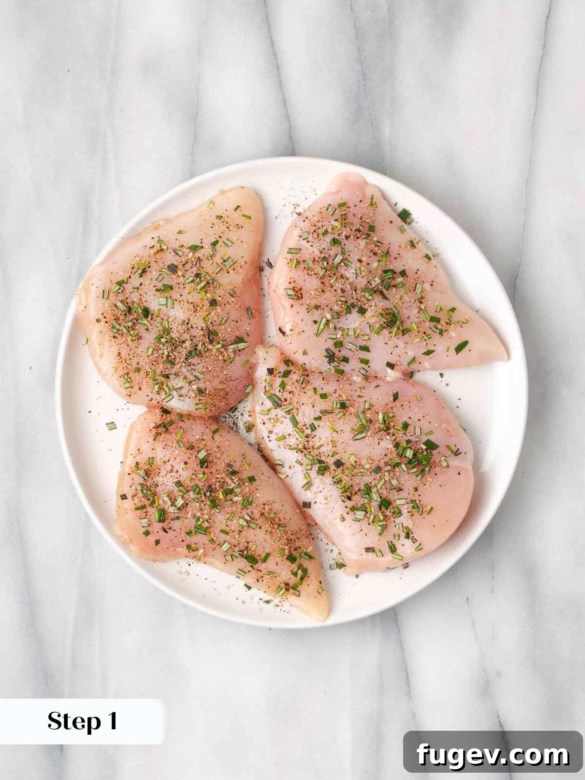 Hearty Marinara Chicken Bake 5 seasoned raw chicken breasts on a white plate, ready for searing.