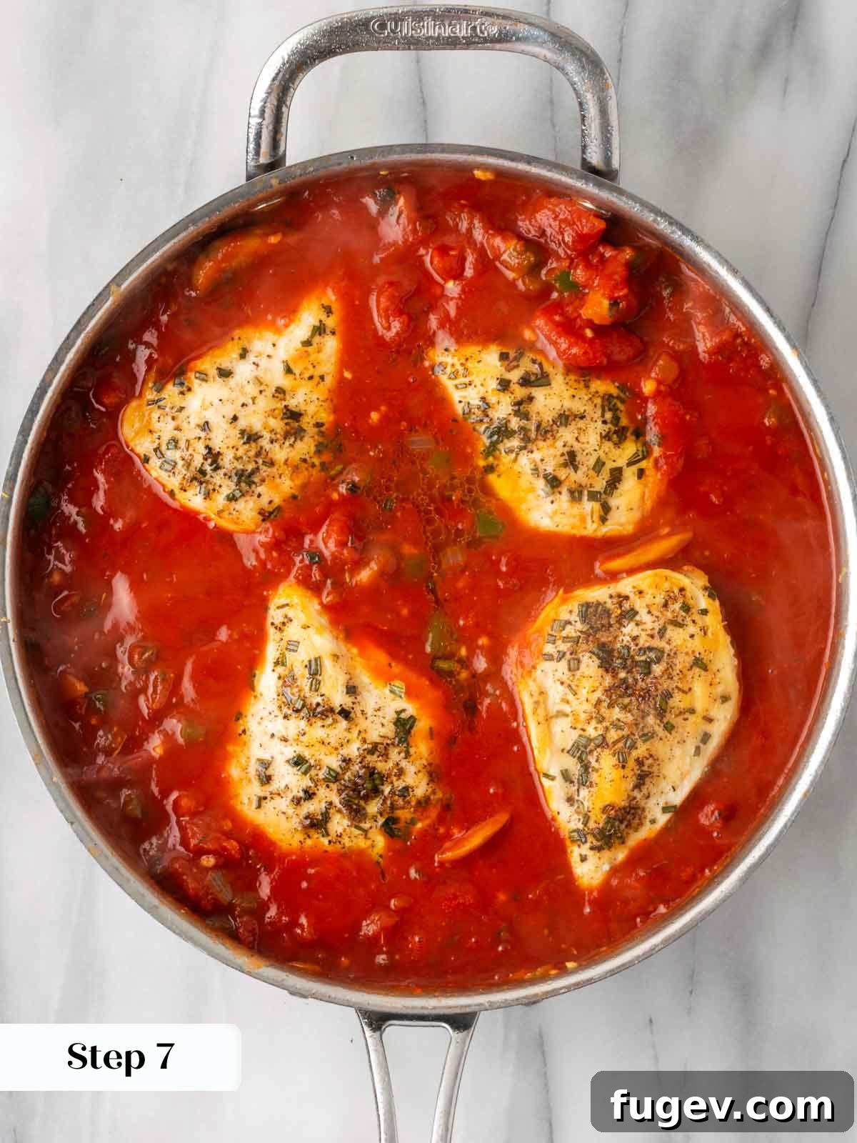 Hearty Marinara Chicken Bake 10 chicken baking in marinara sauce in a stainless steel pan.