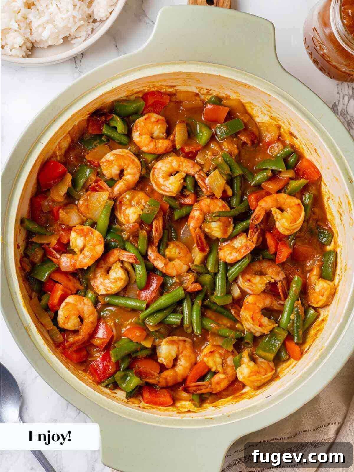 Aromatic Golden Prawns 12 A beautifully plated bowl of shrimp curry with coconut rice, garnished and ready to be served, showcasing the vibrant colors of the dish.