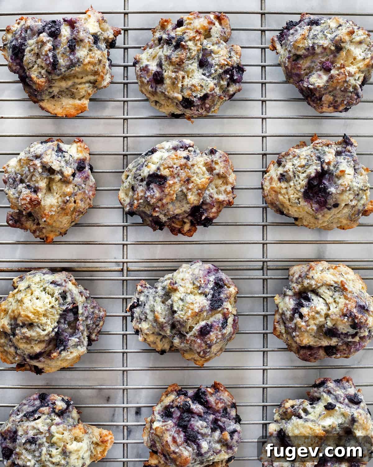 Zesty Lemon Blueberry Scones 8 Freshly baked lemon blueberry scones cooling on a wire rack.