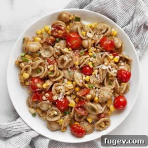 Tomato corn pasta on a plate, ready to eat.