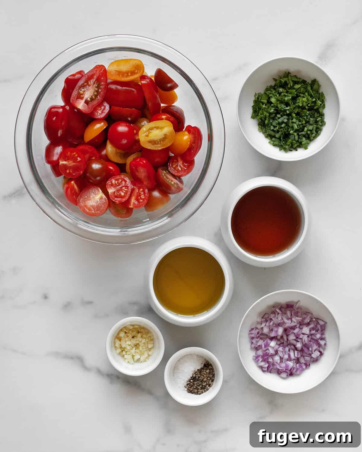 Zesty Marinated Cherry Tomatoes 3 A vibrant selection of ingredients including fresh cherry tomatoes, herbs, garlic cloves, red onions, red wine vinegar, olive oil, salt, and pepper, all ready for the marinated tomato recipe.