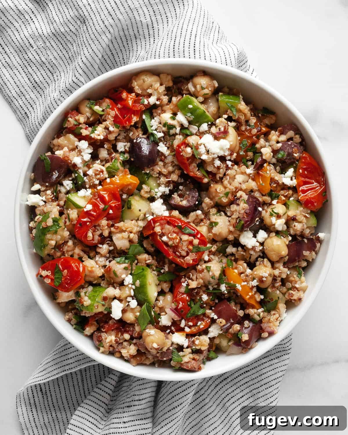 Roasted Tomato Quinoa and Chickpea Medley 2 A small bowl filled with colorful Quinoa Chickpea Salad, garnished with fresh parsley.