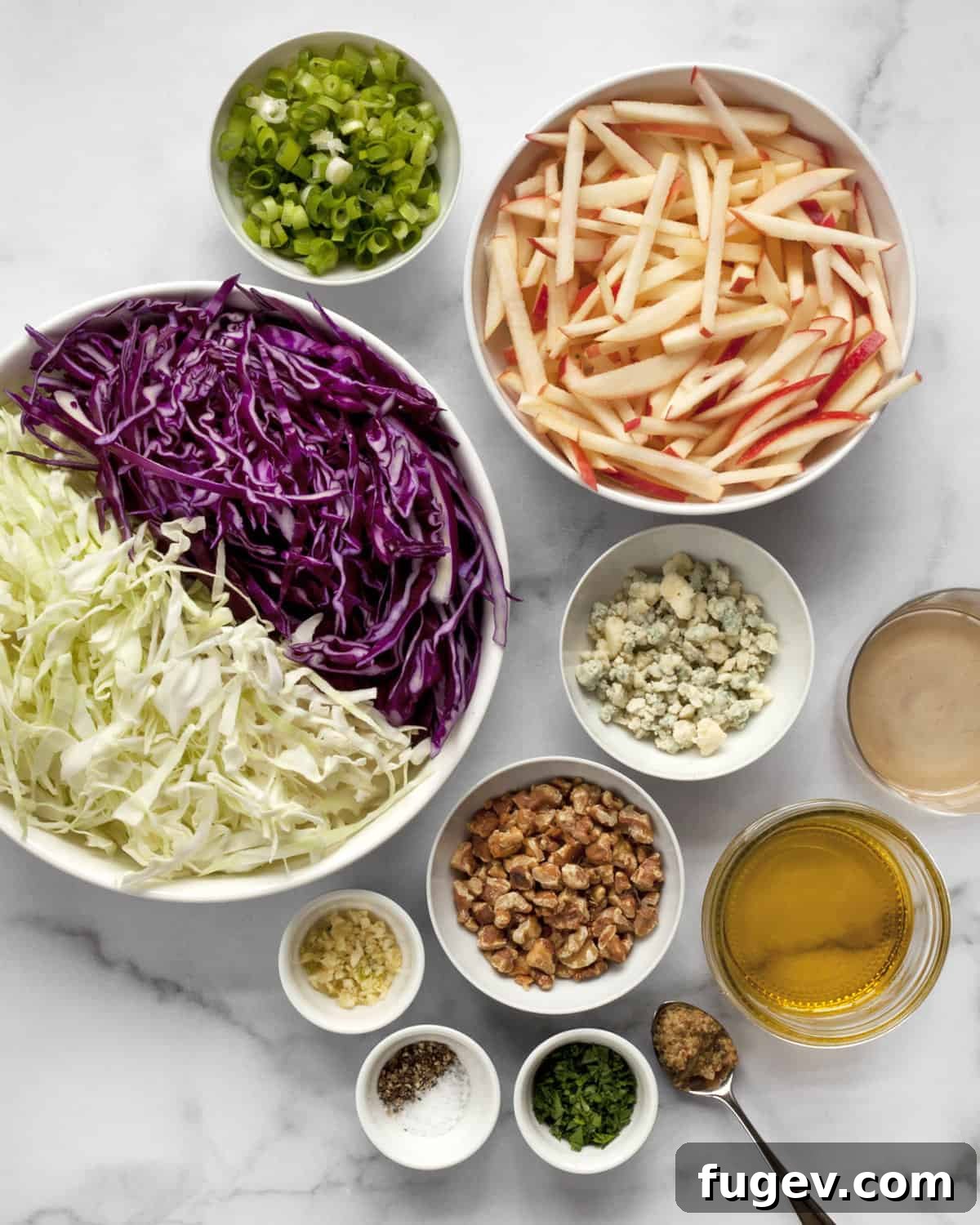 Fresh Ingredients for Apple Cabbage Salad Ingredients for Apple Cabbage Salad laid out, including green and red cabbage, apples, walnuts, blue cheese, and scallions.