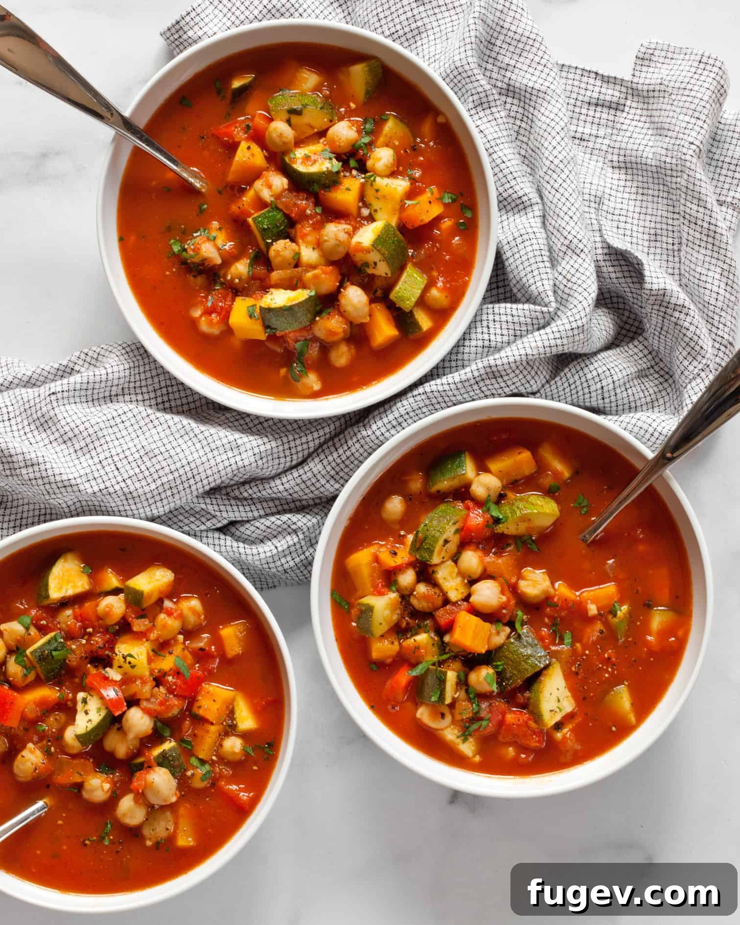Harissalı Nohutlu Sebze Çorbası 2 A vibrant bowl of Chickpea Harissa Vegetable Soup, garnished with fresh parsley.