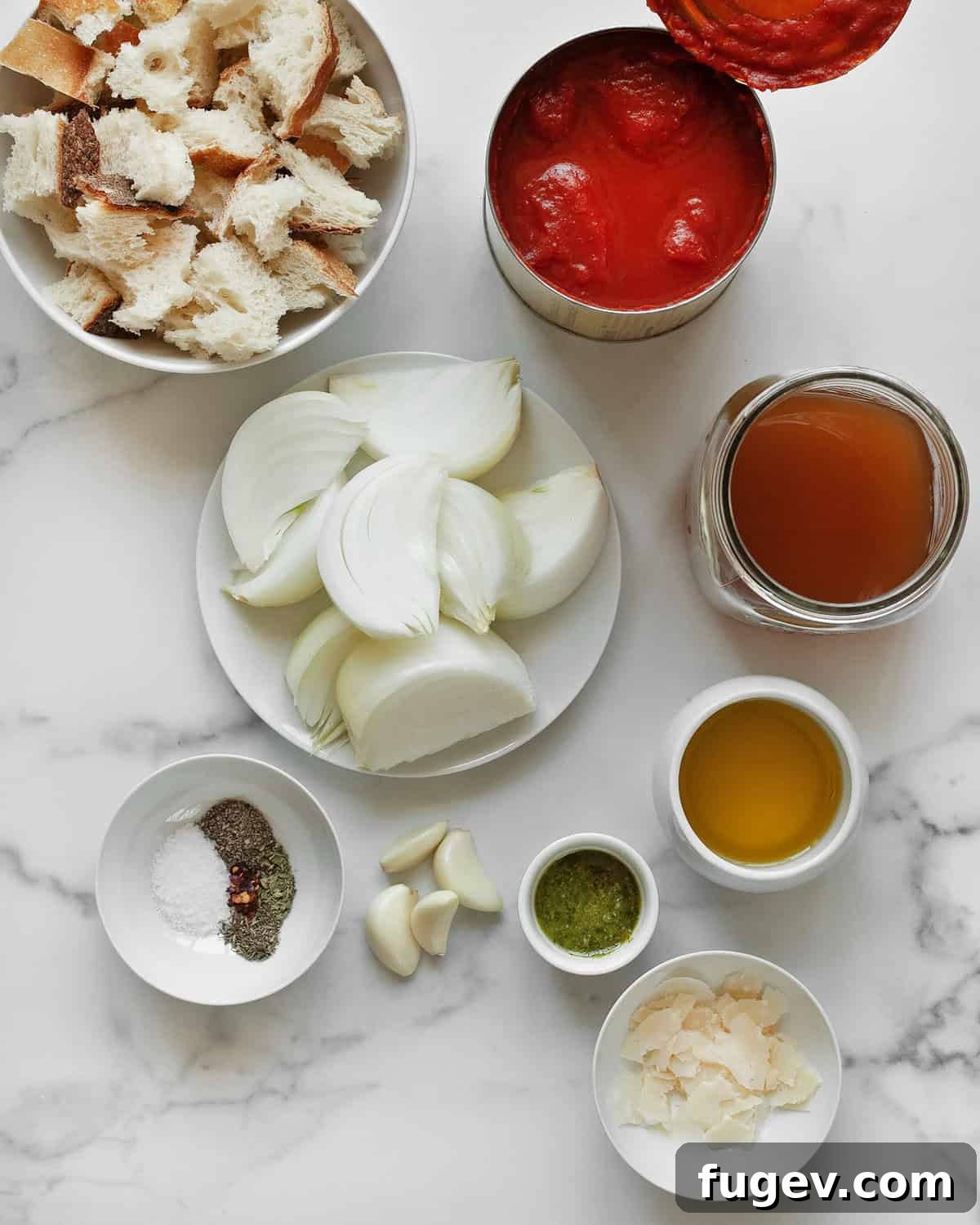 Pantry-Powered Roasted Tomato Soup 3 A curated selection of ingredients for roasted tomato soup: canned tomatoes, whole onions, garlic cloves, dried herbs, olive oil, vegetable broth, and fresh basil pesto.