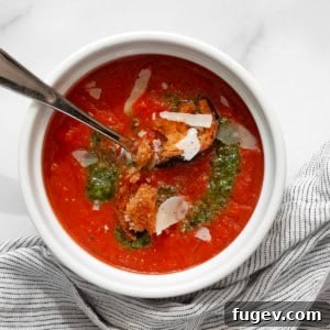 Bowl of roasted tomato soup, garnished.
