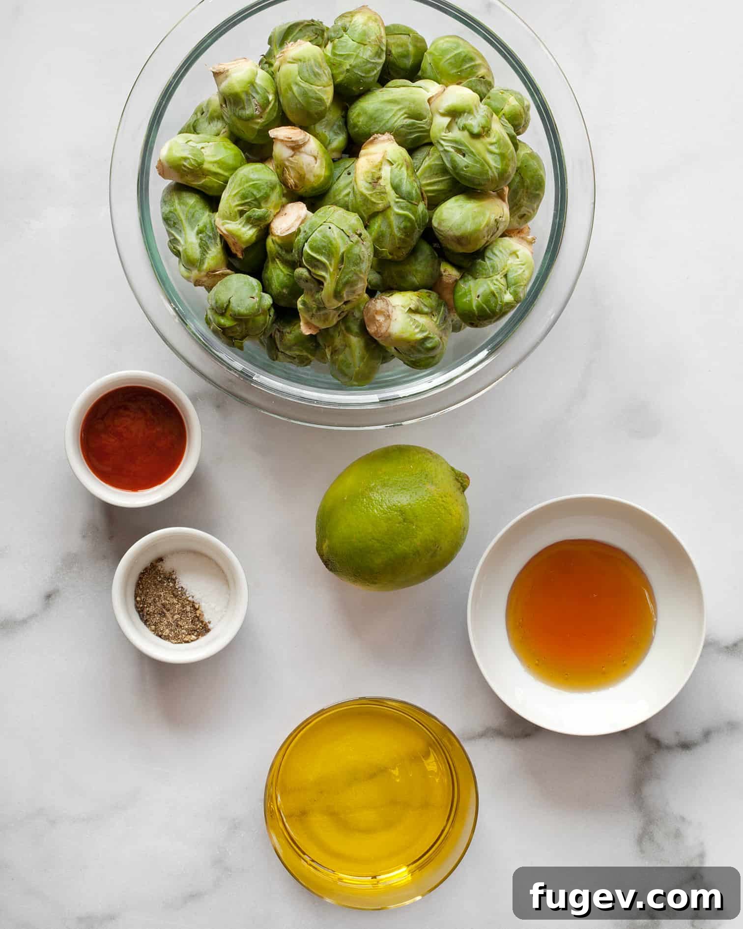 Sticky Sweet Heat Brussels Sprouts 4 Arrangement of fresh Brussels sprouts, lime, honey, olive oil, and a bottle of sriracha, ready for cooking