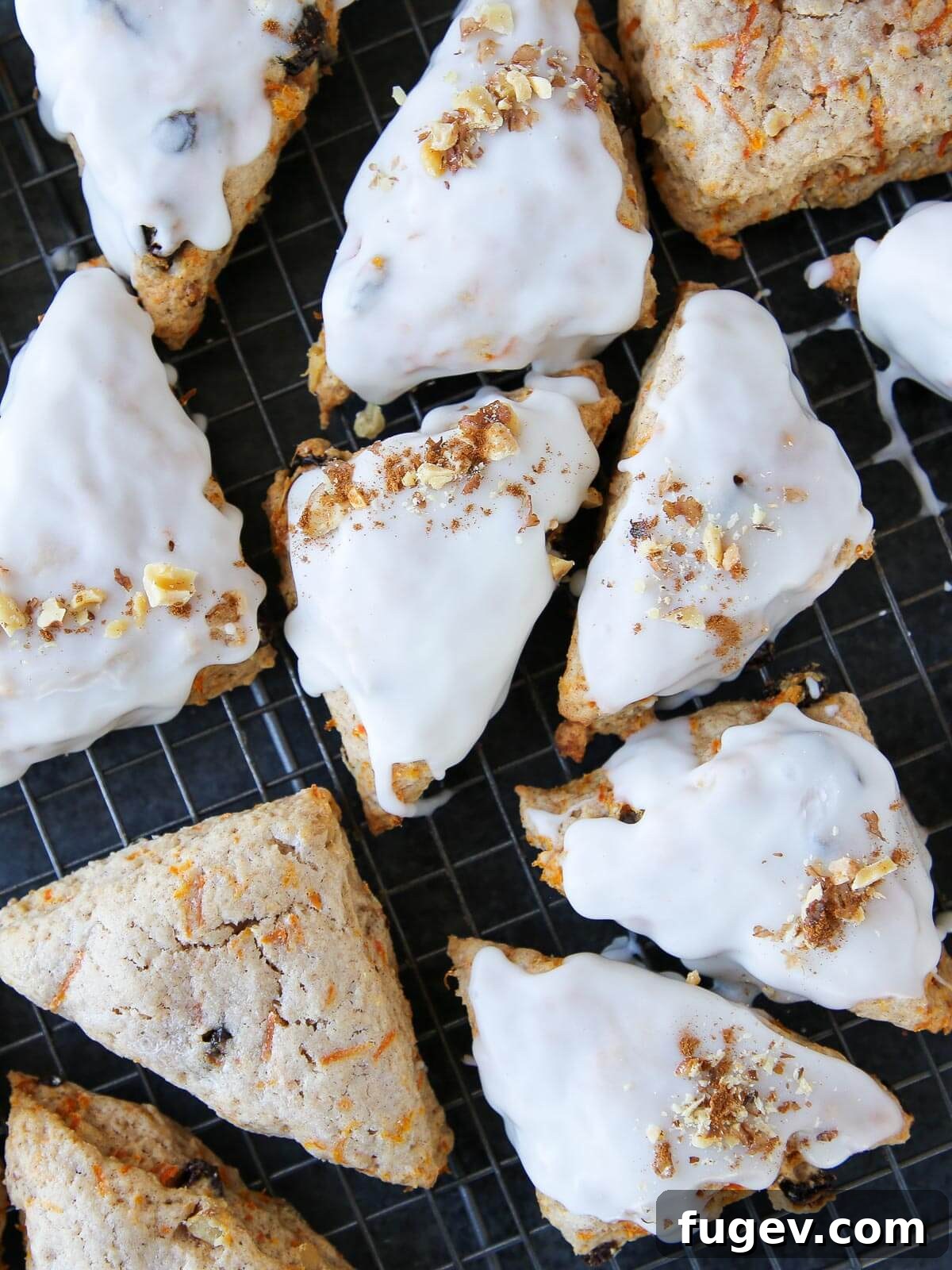 Spiced Carrot Scones 2 A batch of golden-brown carrot cake scones, generously topped with cream cheese glaze and ready to serve.