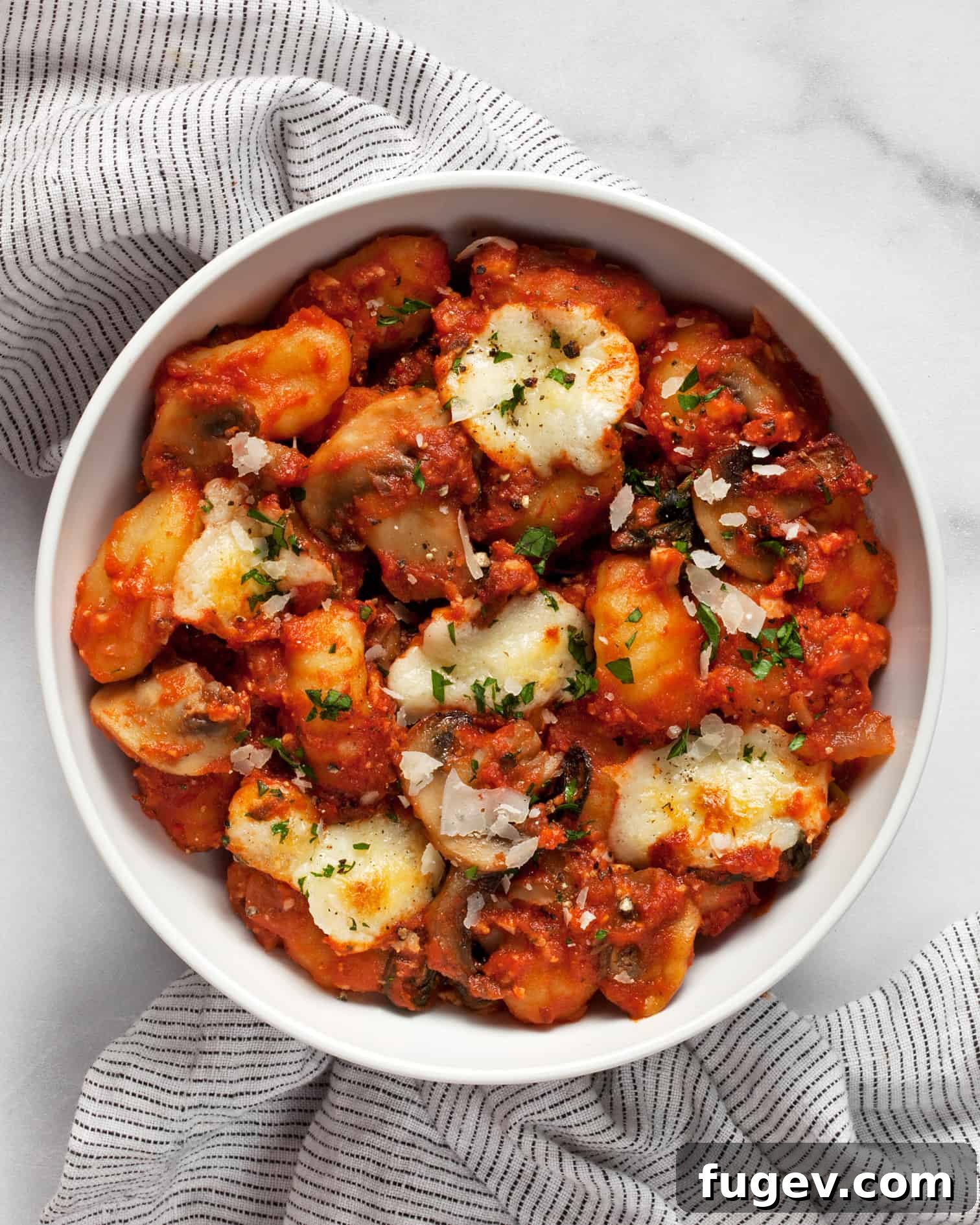 Hearty Mushroom & Spinach Gnocchi Bake 8 Close-up of baked gnocchi with melted cheese and fresh herbs, ready to serve