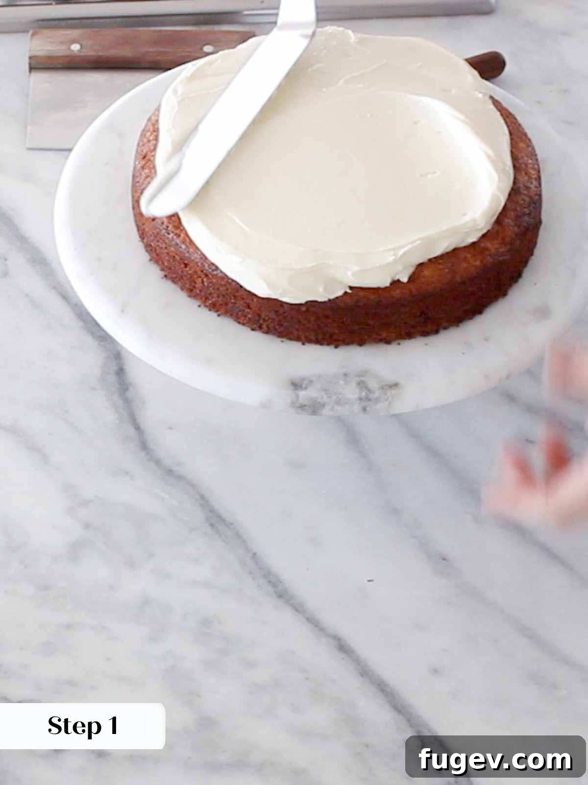 Sweet Nectar Delight 12 spreading cream cheese buttercream on top of first layer.