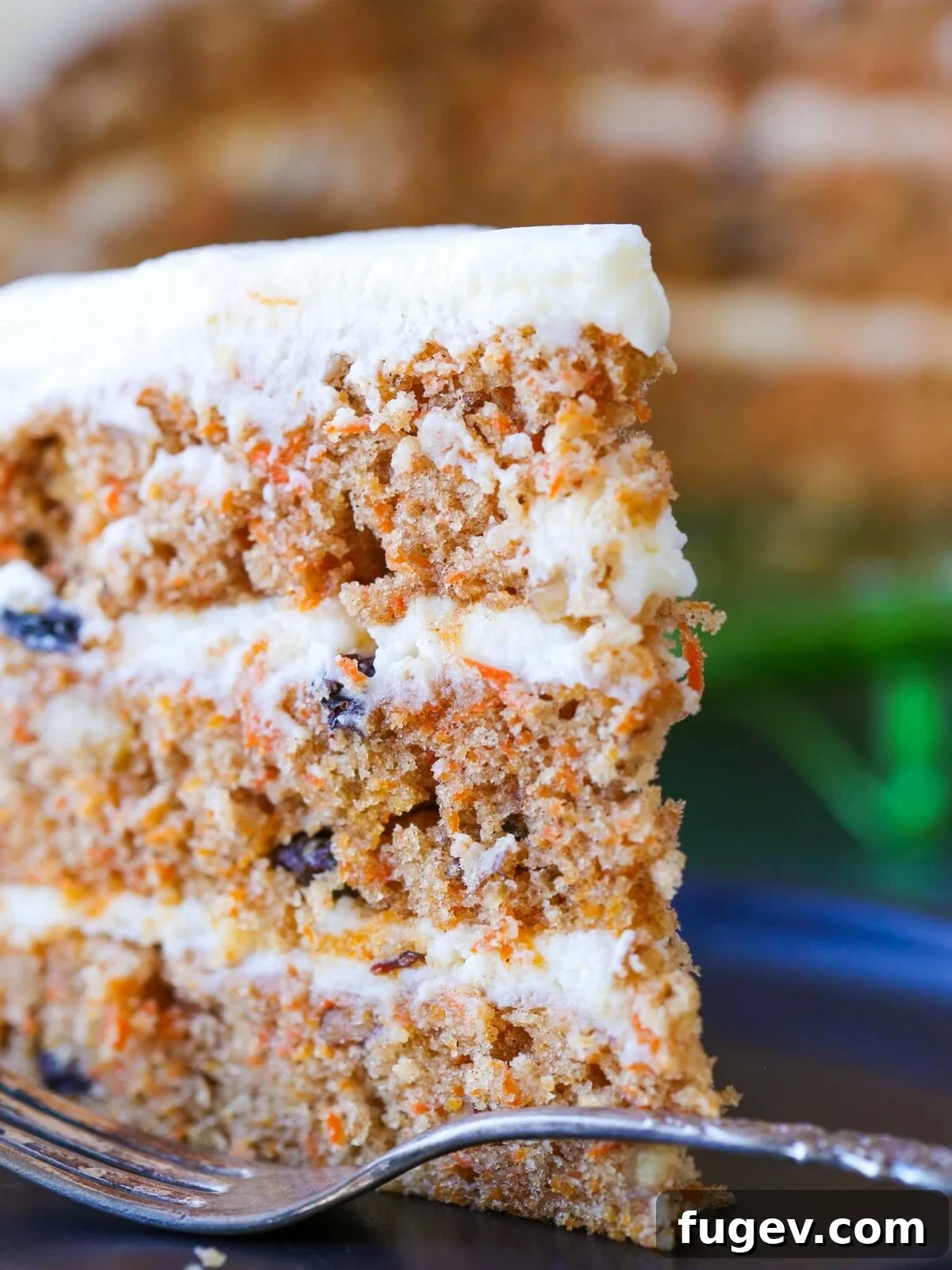 Foolproof Carrot Cake Recipe 2 A beautiful side view of a three-layer carrot cake frosted with luscious cream cheese buttercream.