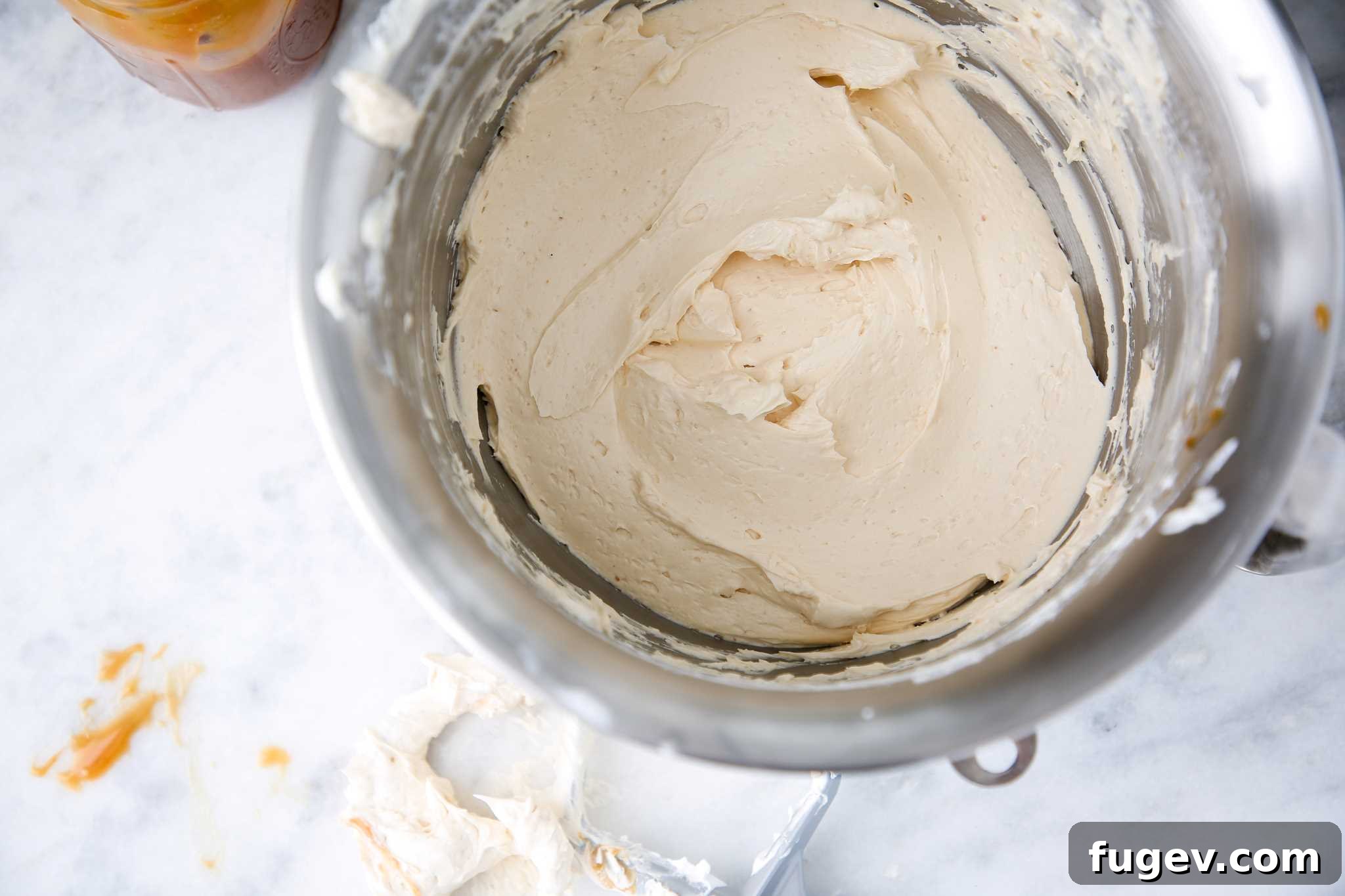 Caramel Swiss Meringue Buttercream in a silver mixing bowl, ready to be used.