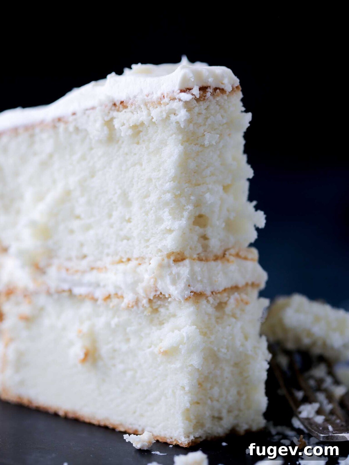 Elegant White Layer Cake 2 A slice of perfect white cake revealing its fluffy, airy interior.